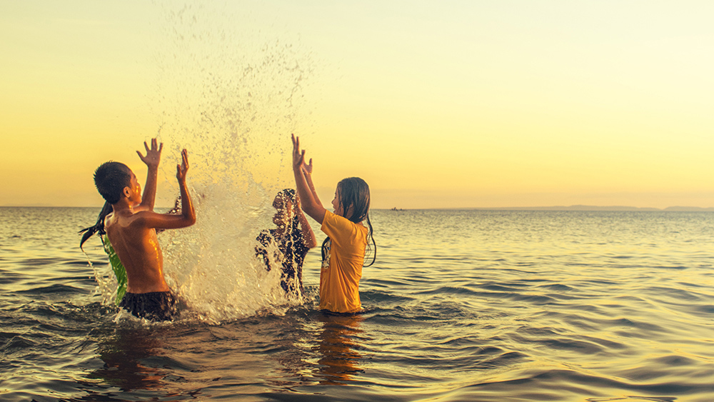image of children splashing in ocean